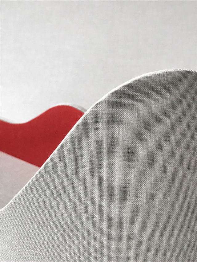 Curved gray fabric edge over red wave