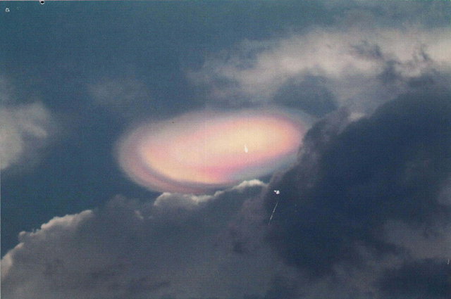 Iridescent lenticular cloud glowing pink against dark sky